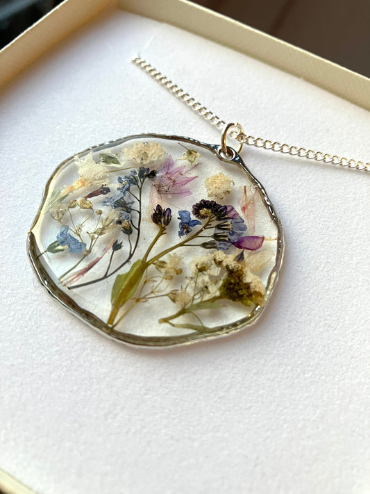 Real pressed flower necklace. Forget me nots, baby’s breath, blossom, In silver with a silver chain. 40mm size.