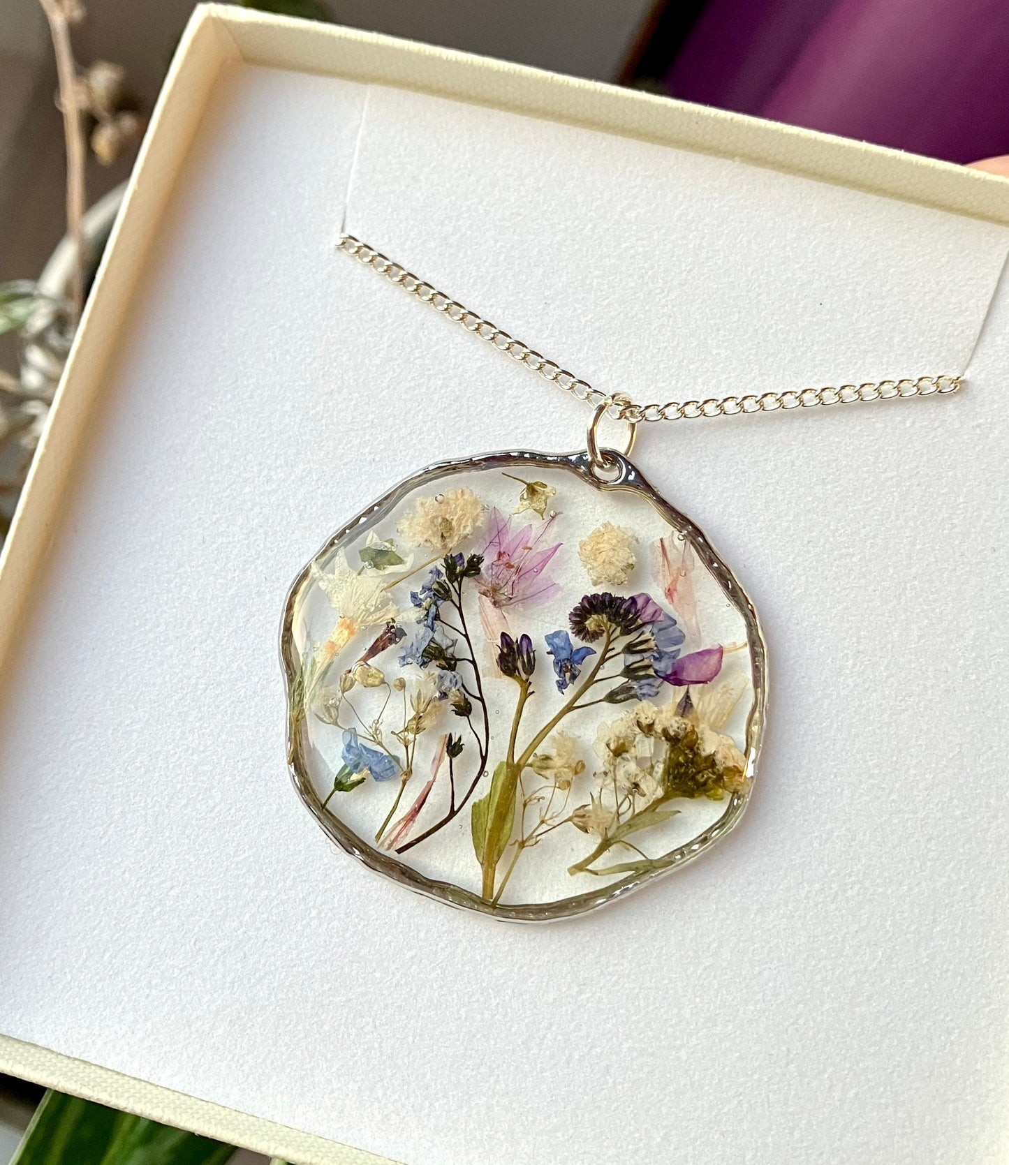 Real pressed flower necklace. Forget me nots, baby’s breath, blossom, In silver with a silver chain. 40mm size.