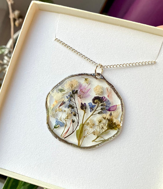 Real pressed flower necklace. Forget me nots, baby’s breath, blossom, In silver with a silver chain. 40mm size.